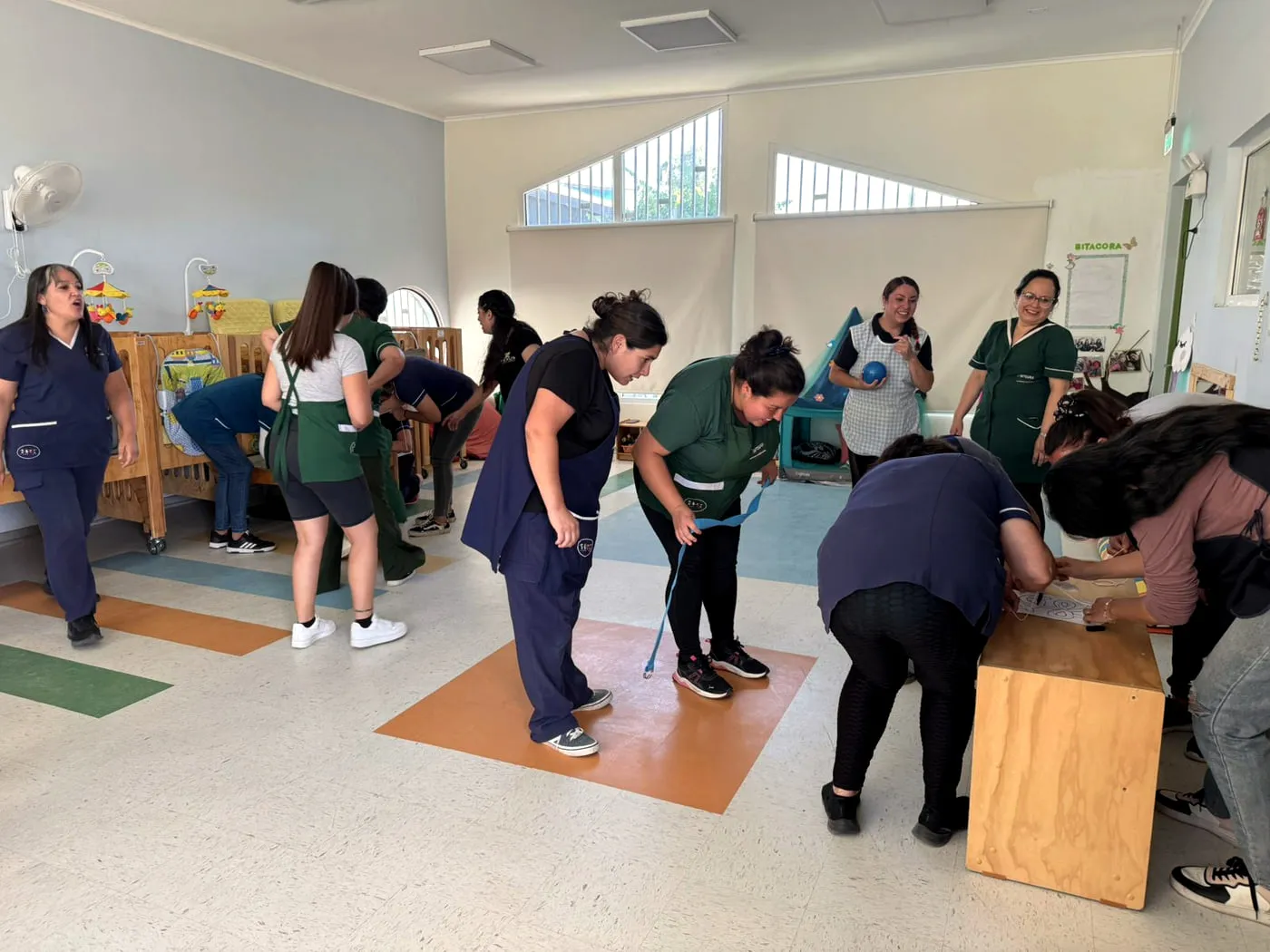 Trabajadoras de un jardín infantil Integra participando en una pausa activa lúdica con juegos de movimiento.